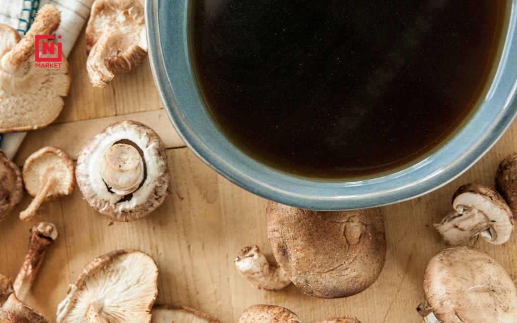 Finished broth mushroom being poured into a glass jar for storage