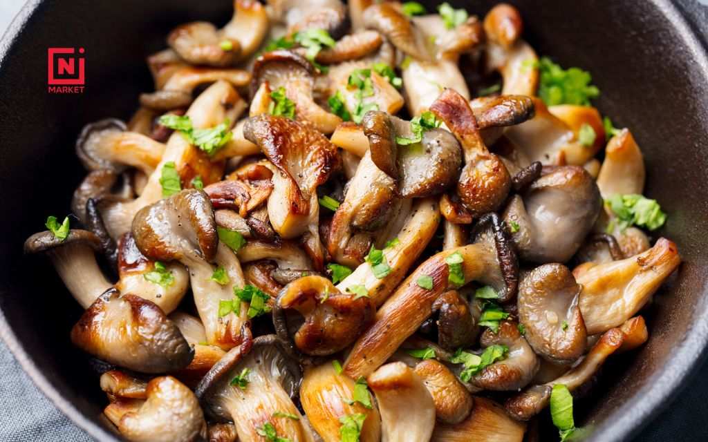 Oyster mushrooms cooking in pot with garlic and onions