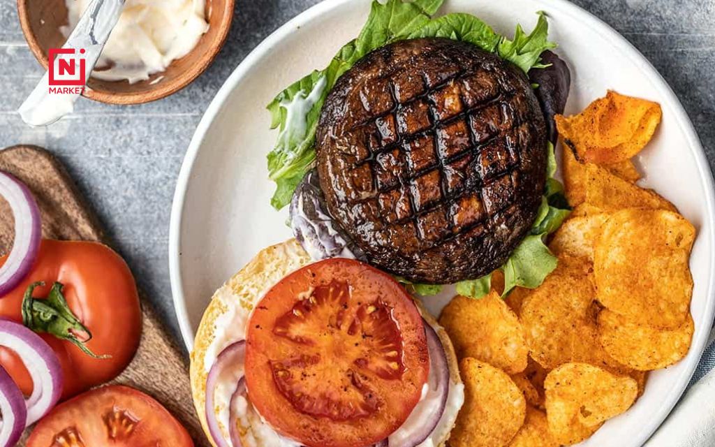 Marinated portobello mushroom caps on hot grill ready to become burgers