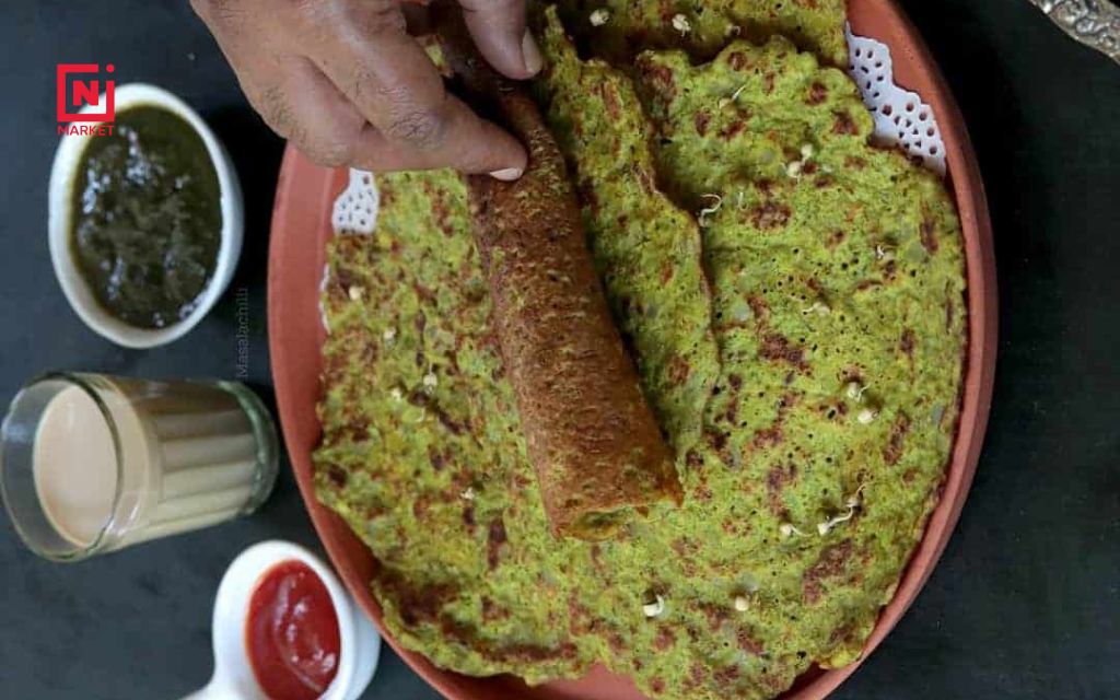 Healthy breakfast plate featuring protein-rich green moong dal chilla with yogurt and vegetables