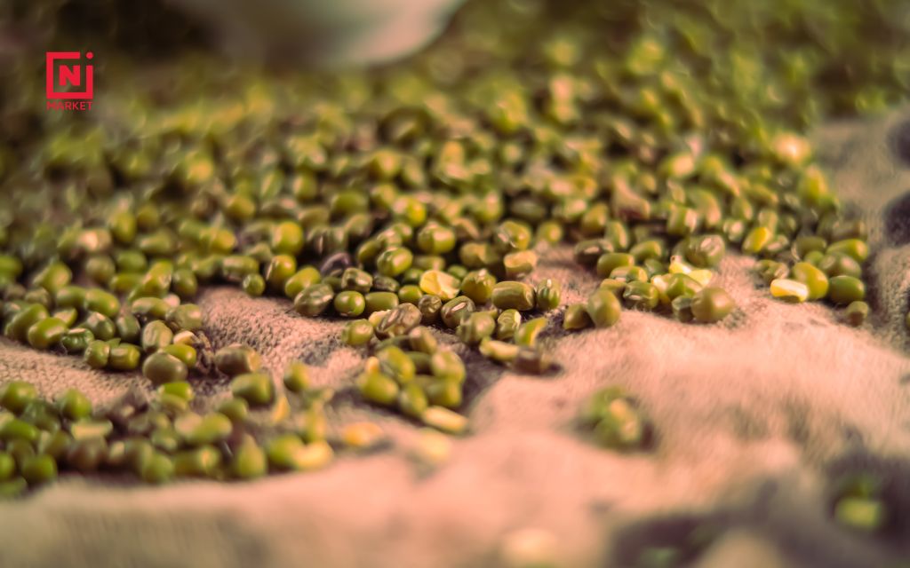 Spreading green moong dal chilla batter on a hot griddle for perfect cooking